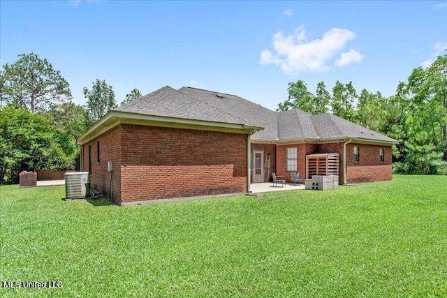 19101 Rucks Krans Rd, Moss Point, MS 39562 - back of property with cooling unit, a patio area, brick siding, and a yard