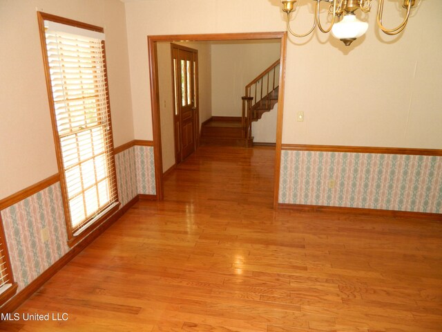 hall with light hardwood / wood-style floors and a chandelier