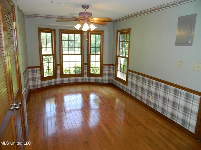 spare room featuring hardwood / wood-style floors, electric panel, and ceiling fan