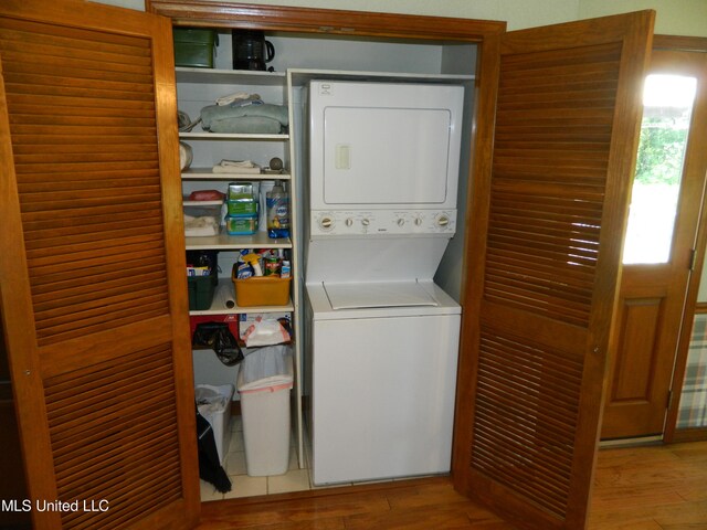 washroom with stacked washer / dryer and light hardwood / wood-style floors