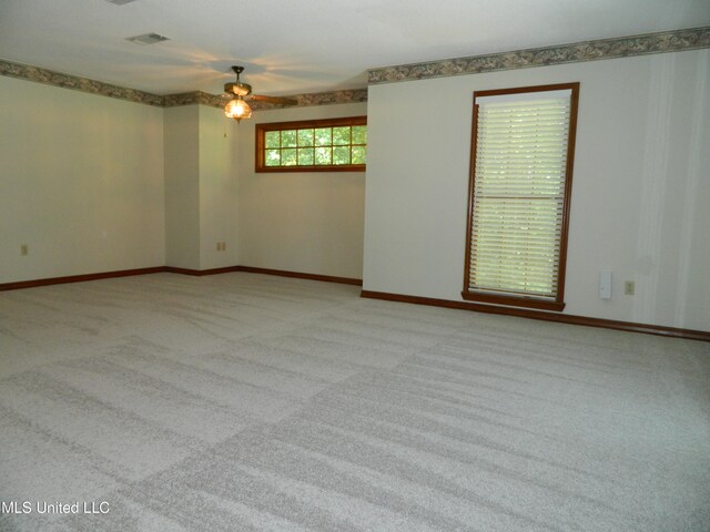 carpeted spare room featuring ceiling fan