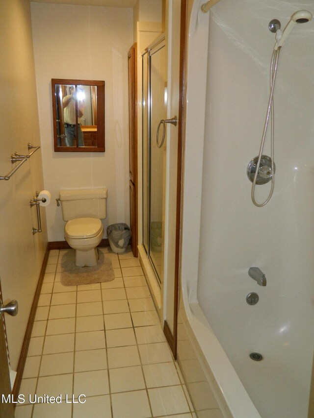 bathroom featuring toilet, a shower, and tile patterned flooring