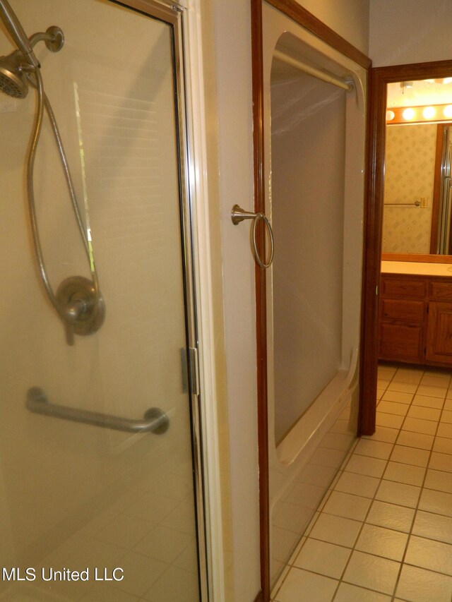 bathroom with an enclosed shower and tile patterned flooring