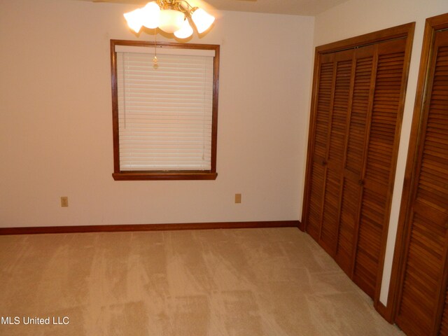 unfurnished bedroom featuring light carpet and a closet