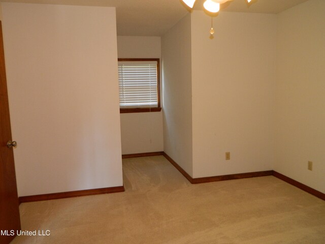 empty room featuring light carpet and ceiling fan