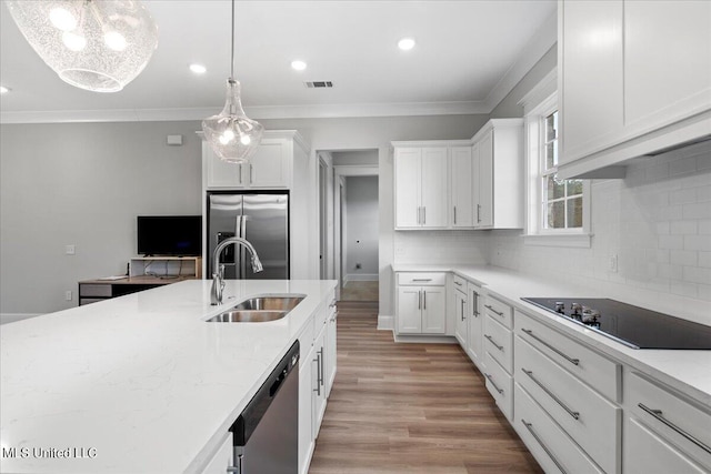 kitchen featuring hanging light fixtures, appliances with stainless steel finishes, sink, and white cabinets