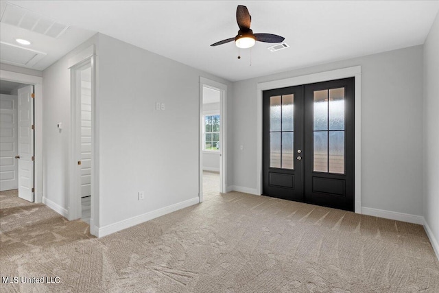 carpeted entrance foyer featuring french doors and ceiling fan