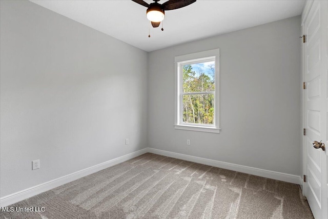 carpeted spare room with ceiling fan