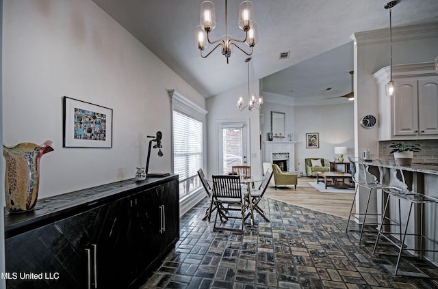 312 Faith Way, Brandon, MS 39042 - dining area with a chandelier, a fireplace, lofted ceiling, and brick flooring