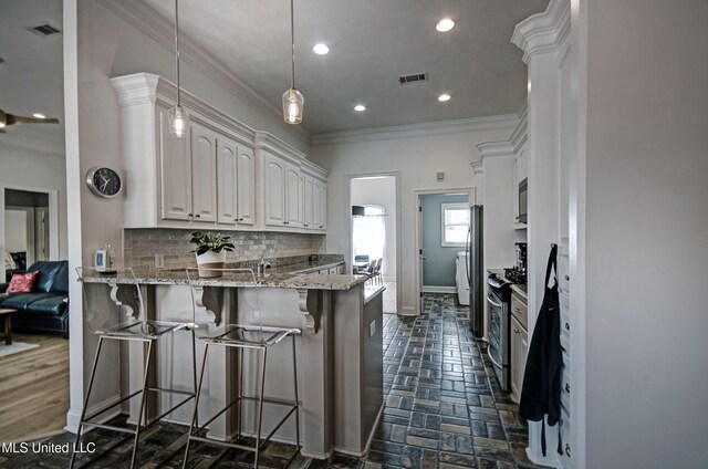 312 Faith Way, Brandon, MS 39042 - kitchen with crown molding, a peninsula, stainless steel appliances, tasteful backsplash, and a breakfast bar area