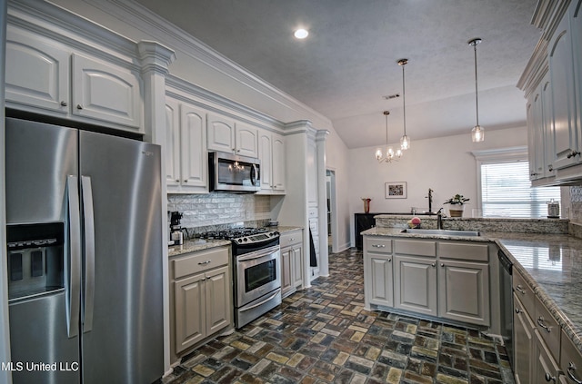 312 Faith Way, Brandon, MS 39042 - kitchen featuring stainless steel appliances, decorative backsplash, brick floors, lofted ceiling, and a peninsula