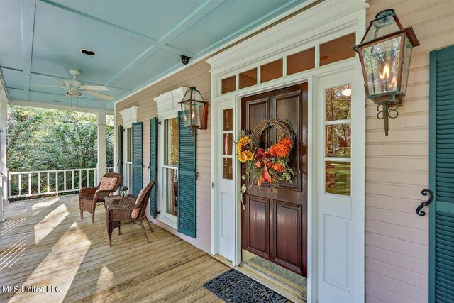 view of exterior entry with a porch and a ceiling fan