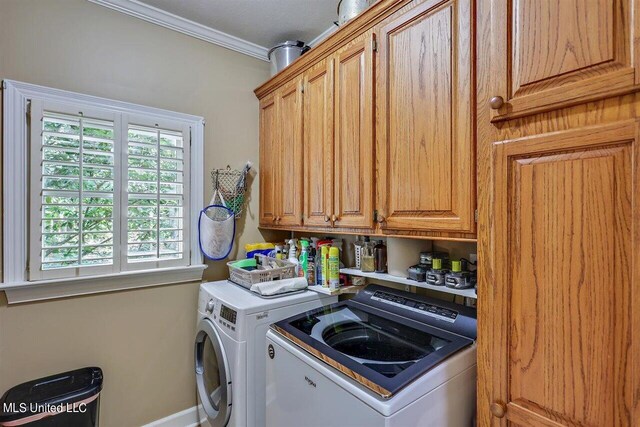 clothes washing area with washing machine and clothes dryer, baseboards, ornamental molding, and cabinet space