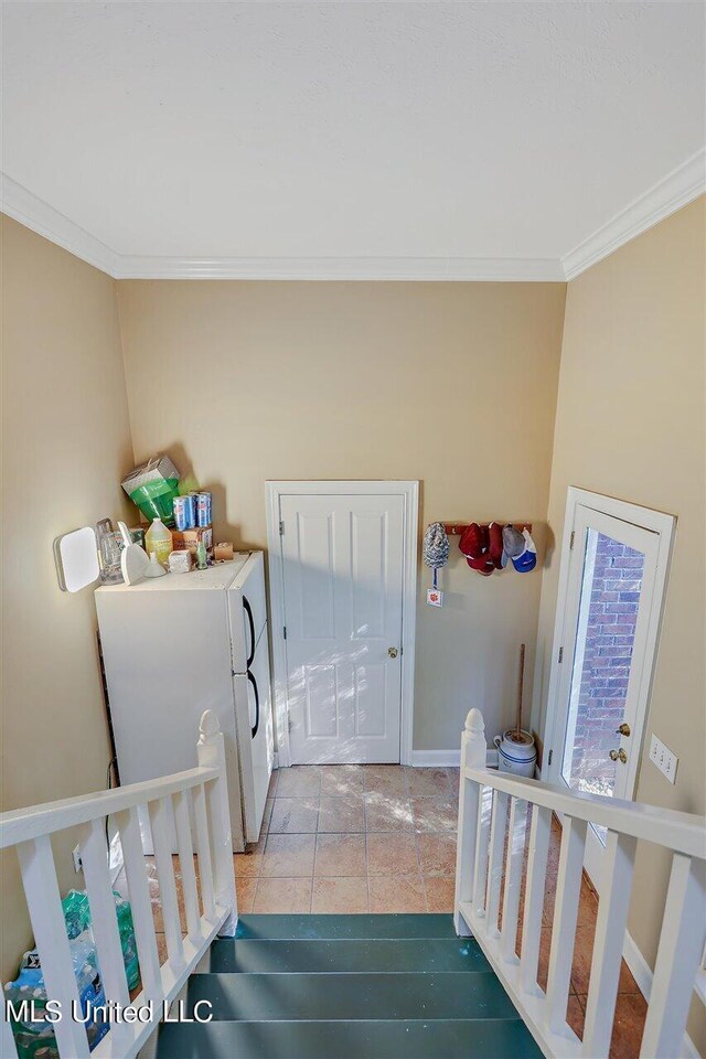 laundry area featuring crown molding and baseboards
