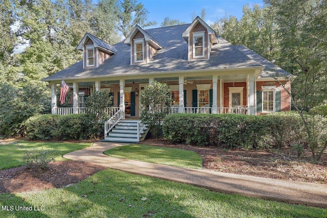 cape cod home with covered porch and a front lawn