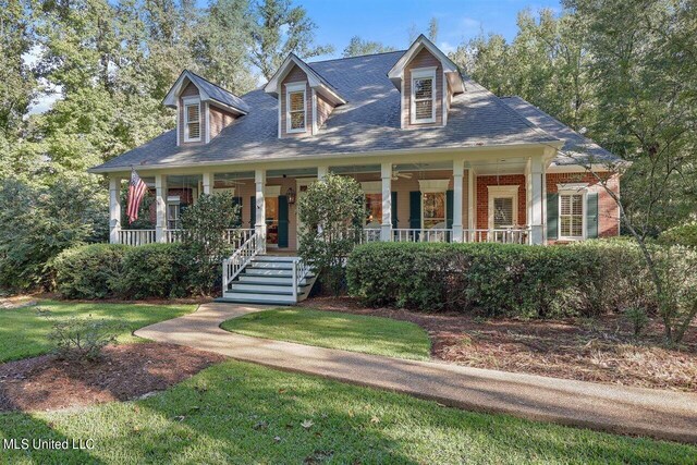 view of front of house featuring a porch, brick siding, and a front yard