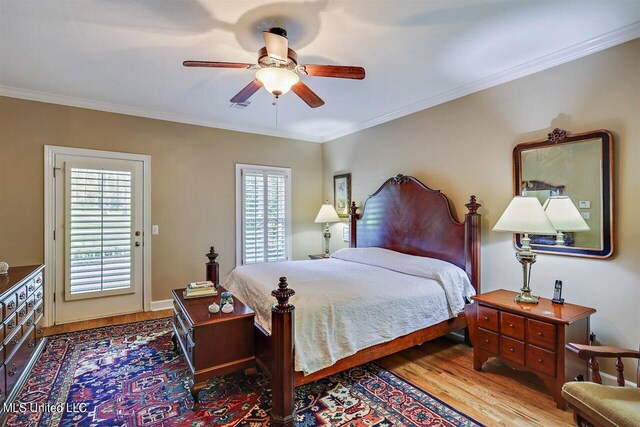 bedroom with crown molding, ceiling fan, wood finished floors, and visible vents
