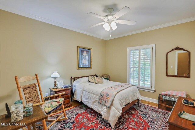 bedroom featuring baseboards, ornamental molding, ceiling fan, and wood finished floors
