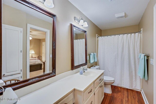 full bath with vanity, ensuite bathroom, toilet, and wood finished floors