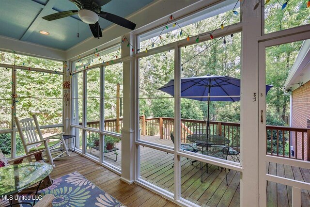 sunroom / solarium with ceiling fan and outdoor dining area