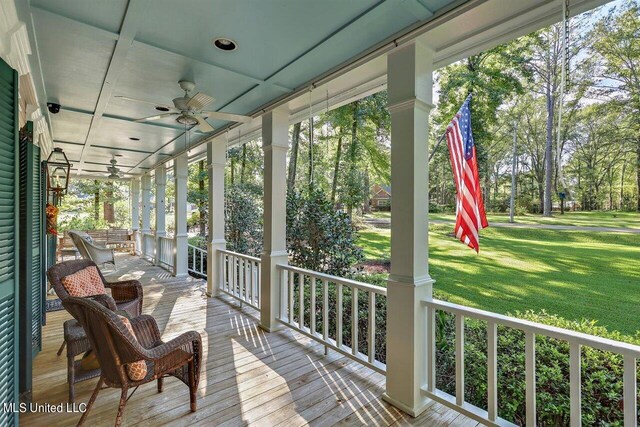 exterior space with a lawn, covered porch, and ceiling fan