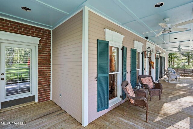 wooden deck with a porch and ceiling fan