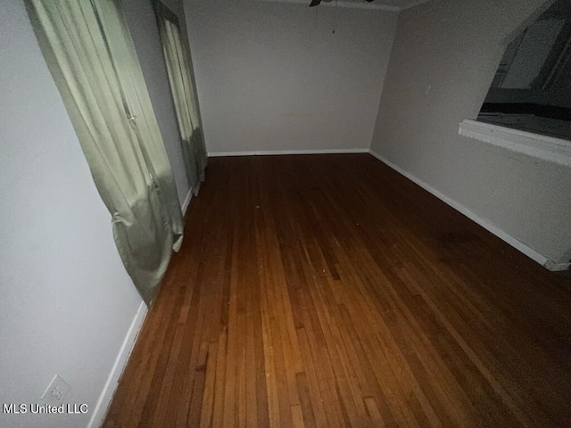 spare room featuring a ceiling fan, baseboards, and wood finished floors