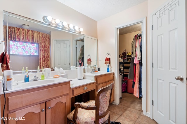 bathroom with tile patterned flooring, vanity, and a textured ceiling