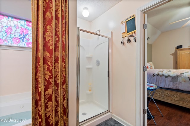 bathroom featuring hardwood / wood-style floors, a shower with door, a textured ceiling, and lofted ceiling