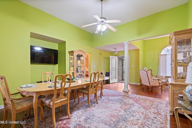 dining space featuring wood-type flooring, ceiling fan, and decorative columns