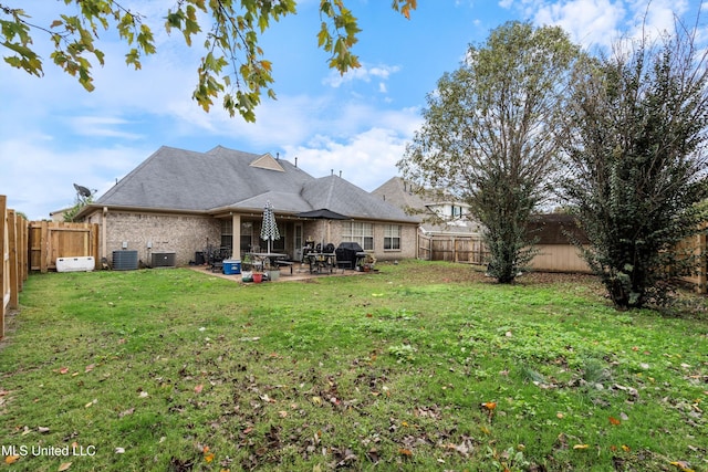 back of property with central AC unit, a lawn, and a patio