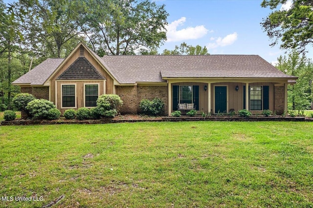 ranch-style house featuring a front yard and a shingled roof