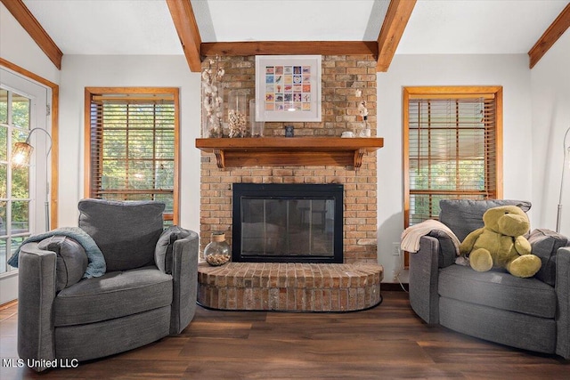 living room featuring beam ceiling, dark wood-type flooring, and a brick fireplace