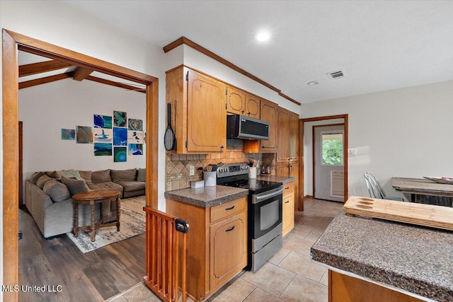 kitchen featuring tasteful backsplash, light hardwood / wood-style floors, stainless steel appliances, beam ceiling, and ornamental molding