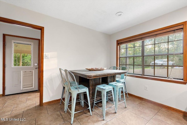 dining room with baseboards and light tile patterned floors