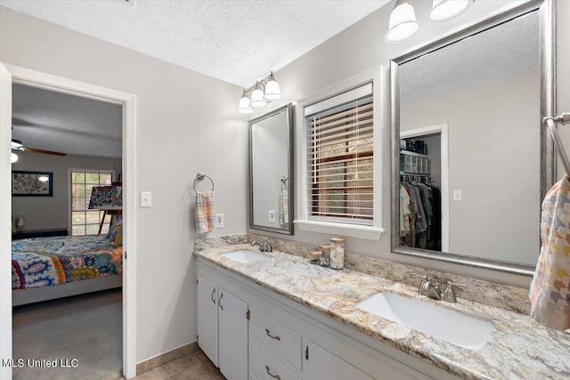 bathroom featuring vanity, a textured ceiling, and ceiling fan