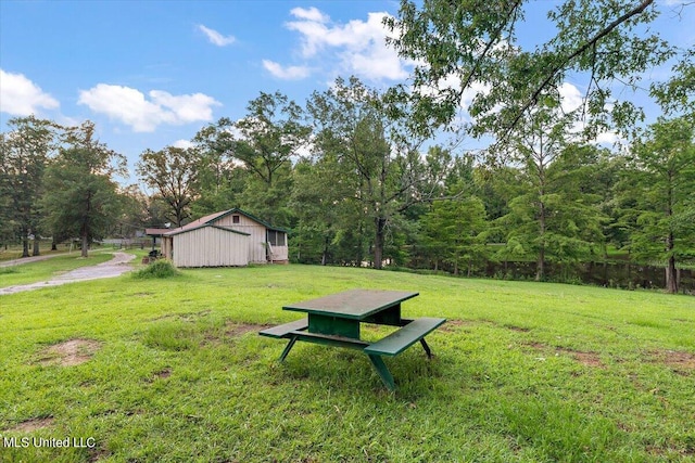 view of yard with a wooded view and an outbuilding