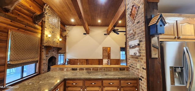 kitchen featuring plenty of natural light, beam ceiling, stainless steel fridge with ice dispenser, and a brick fireplace