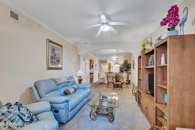 carpeted living room featuring crown molding, ornate columns, and ceiling fan