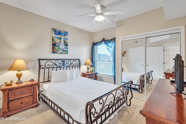bedroom featuring visible vents, a closet, ceiling fan, and light colored carpet