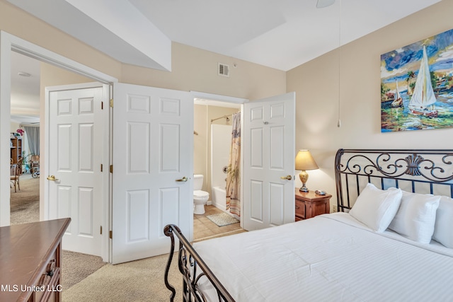 carpeted bedroom featuring ensuite bath