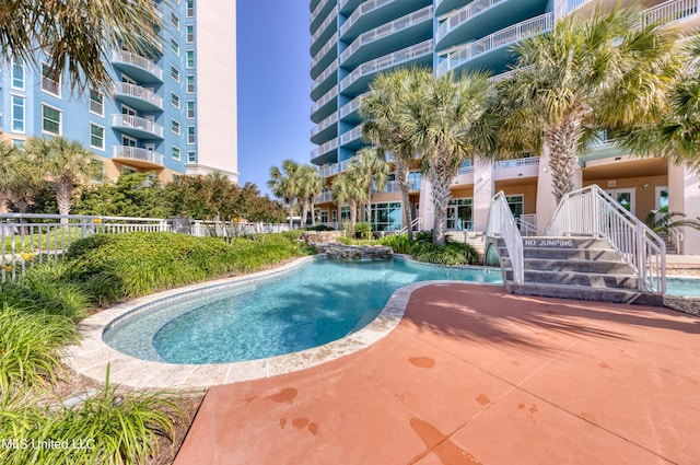 community pool with fence and a patio area