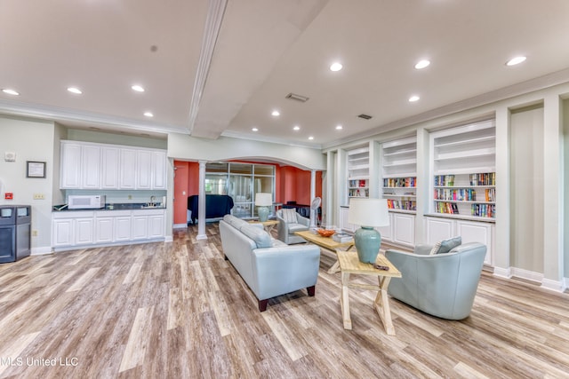 living room with crown molding and light hardwood / wood-style flooring