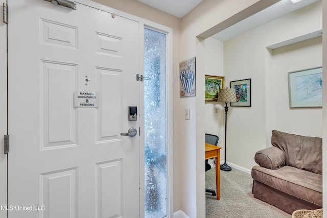 carpeted entrance foyer featuring baseboards