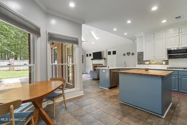 410 Woodland Hills Ct, Madison, MS 39110 - kitchen featuring wooden counters, a kitchen island, stainless steel appliances, white cabinets, and backsplash
