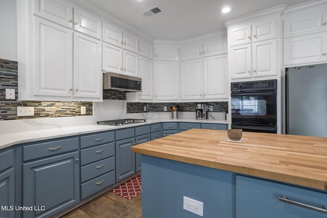 410 Woodland Hills Ct, Madison, MS 39110 - kitchen with wood counters, blue cabinetry, appliances with stainless steel finishes, white cabinetry, and recessed lighting