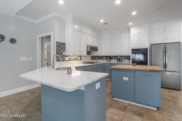 410 Woodland Hills Ct, Madison, MS 39110 - kitchen with appliances with stainless steel finishes, butcher block counters, a peninsula, backsplash, and ornamental molding