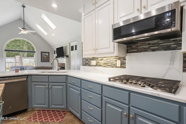 410 Woodland Hills Ct, Madison, MS 39110 - kitchen with appliances with stainless steel finishes, a skylight, a ceiling fan, vaulted ceiling, and backsplash