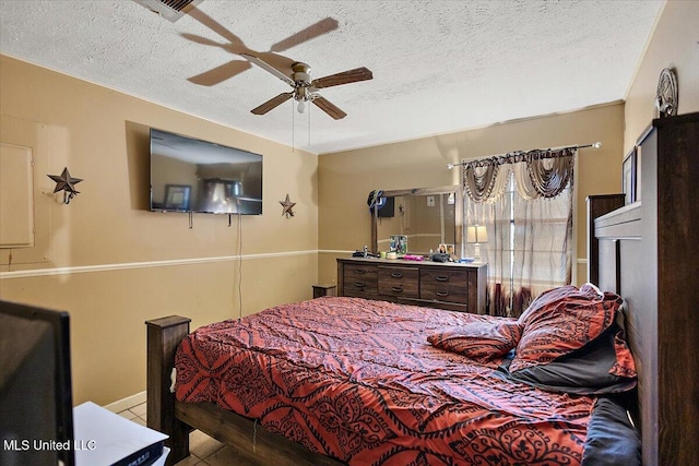 tiled bedroom with a textured ceiling and ceiling fan