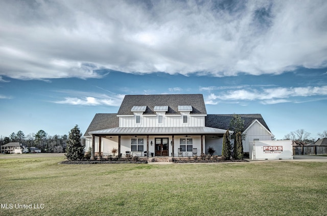 back of property with a yard, a porch, a shingled roof, a standing seam roof, and metal roof